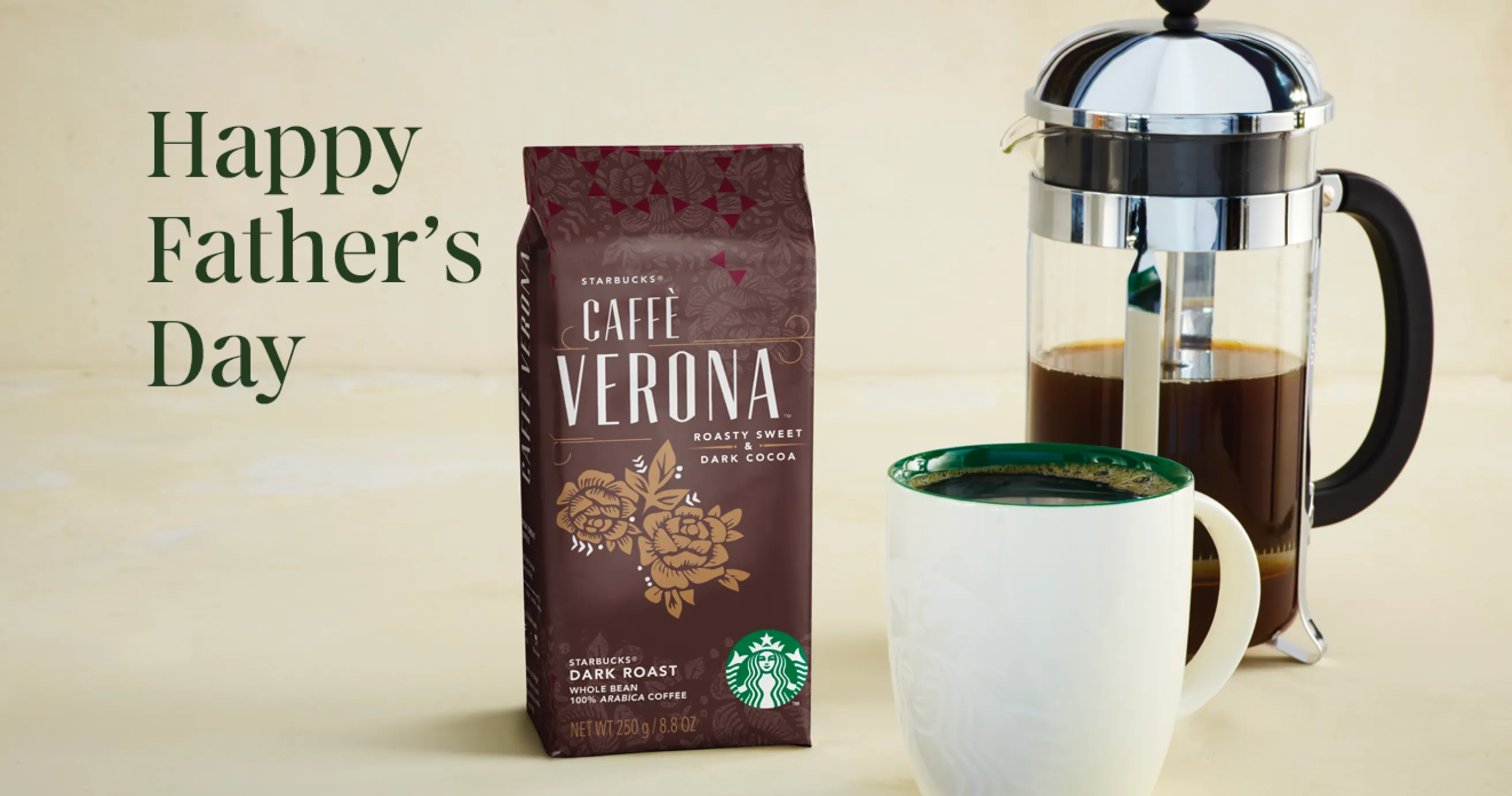 A bag of Starbucks Whole Bean Coffee, french press and mug sit atop a marble counter surface.
