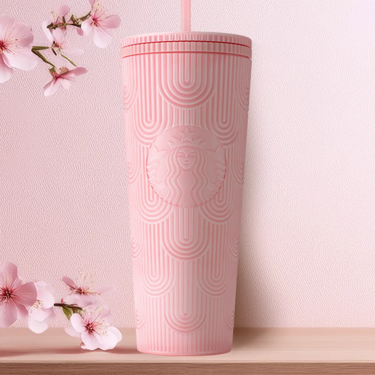 Pearl Pink coloured Cold Cup with embossed Arches in the design, holds 24oz on a tabletop with pink sakura decoration in the background