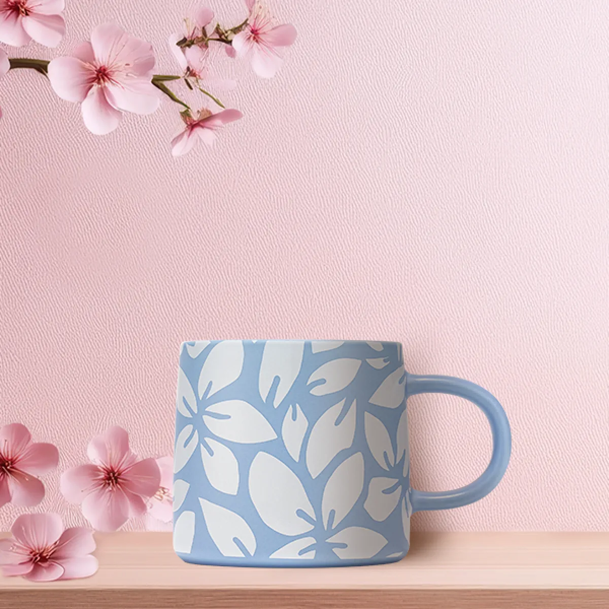 A Blue 12oz ceramic Mug with a while petal 'Spring Breeze' design on a pink sakura decorated background