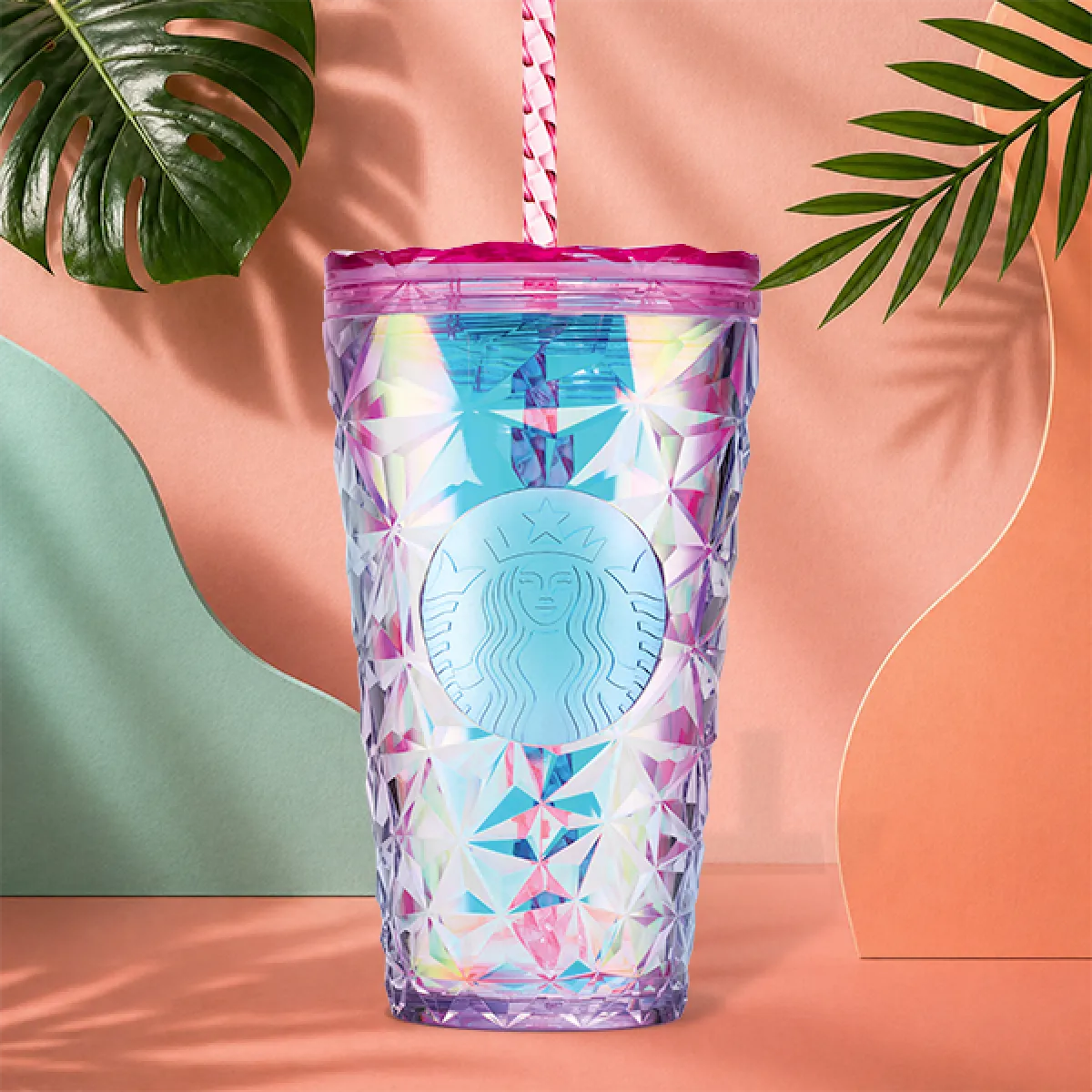 A photo of our new summer prism cold cup - a raspberry tinted, geometric textured plastic cold cup in 16oz. Complete with screw on lid and straw.