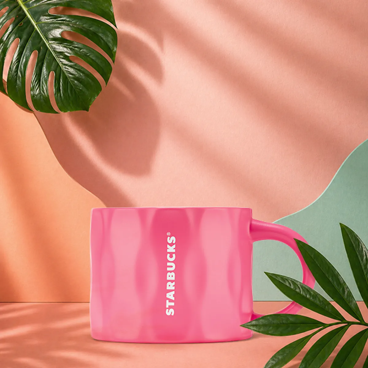 A photo of our new summer raspberry ripple mug - a bright pink ceramic mug, with a wavey ripple texture around the outside.