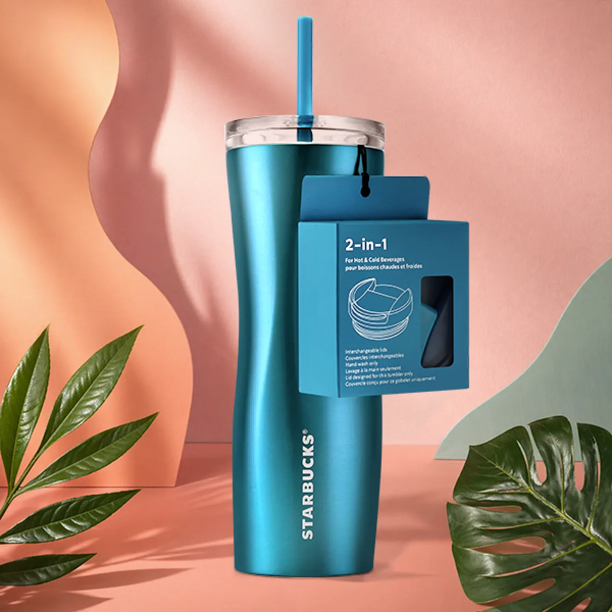 A photo of our new stainless steel, mid-blue tumbler. The sleek wave design gives it an hour-glass look. With 2 lids; one for hot beverages, and one for cold - including a straw! 
