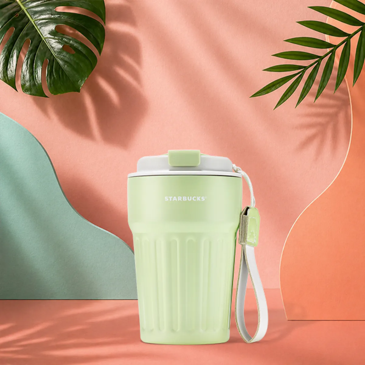 A photo of our new Sage Sundae tumbler, a soft sage green colour with a vertical striped texture, beige click-lid and a handy strap.