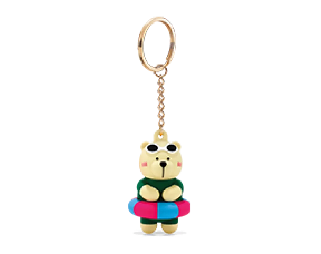 A photo showing our Bearista Buddy Billy Bubble - a bear character keychain wearing swim goggles, a green wetsuit, and blue and pink inflatable pool ring.
