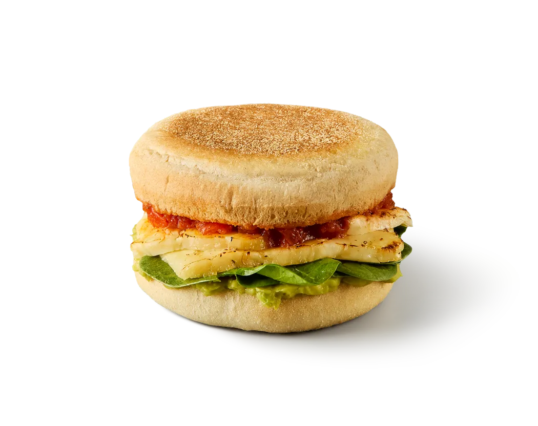 A photo of our new hot honey halloumi breakfast muffin, showing the english muffin, halloumi and avocado filling in its colourful layers.