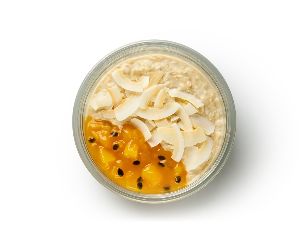 Our mango and passionfruit overnight oats, shot from above, showing the passionfruit compote and shaved coconut on top.