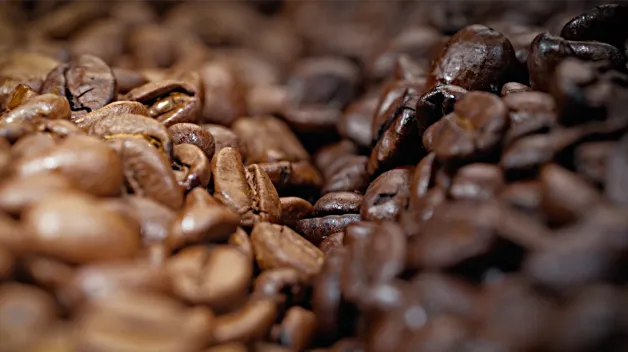 A close up photo of our blonde and dark roasted whole coffee beans
