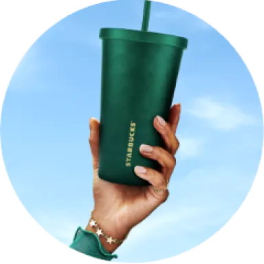 A photo of a hand holding a stainless steel, dark green reusable cold cup with straw into the sky.