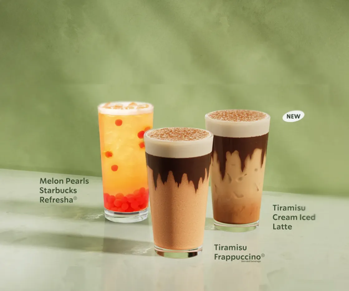 The starbucks summer range sits alot a table against a marbled green background.