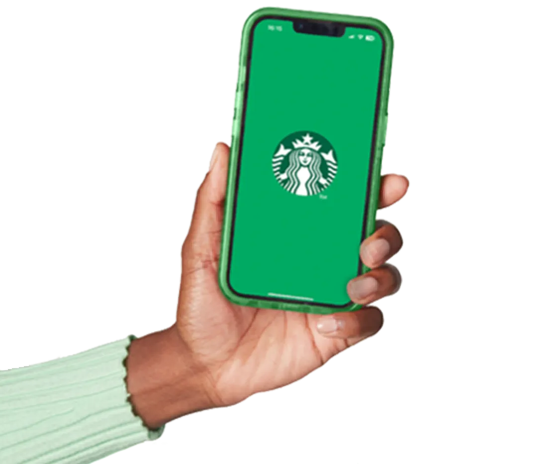 A hand holds a phone showing the Starbucks® UK app