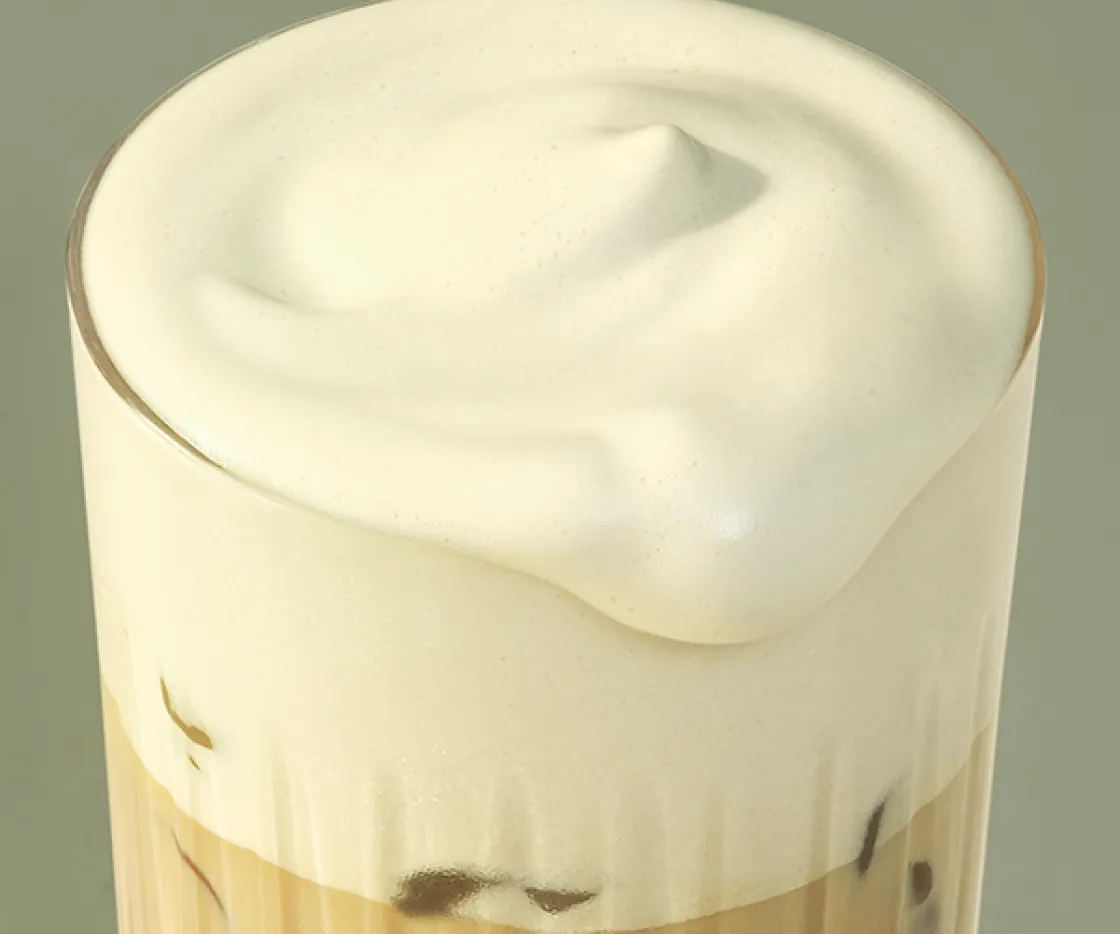 A close up of our new Protein Cold Foam spilling over the edge of a glass