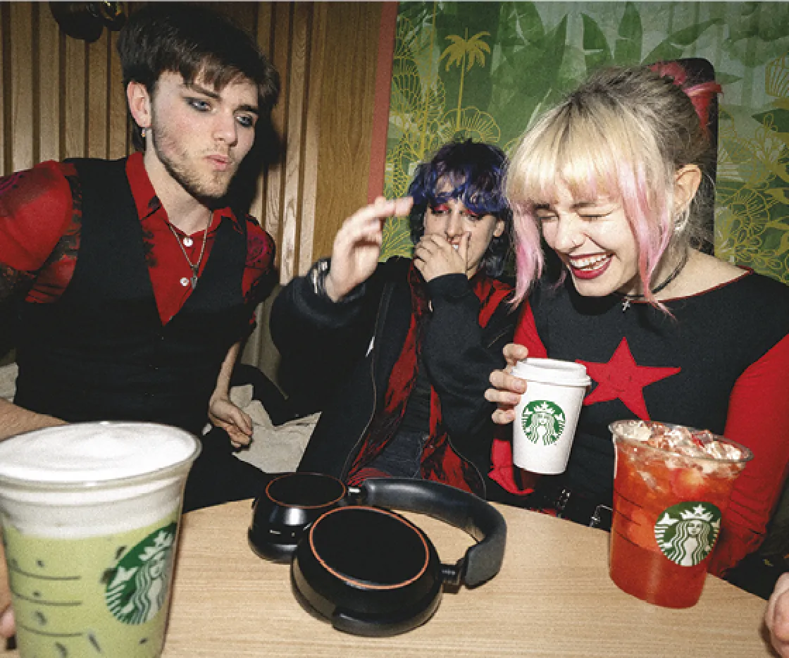 Three friends laughing whilst listening to music at a Starbucks Coffeehouse