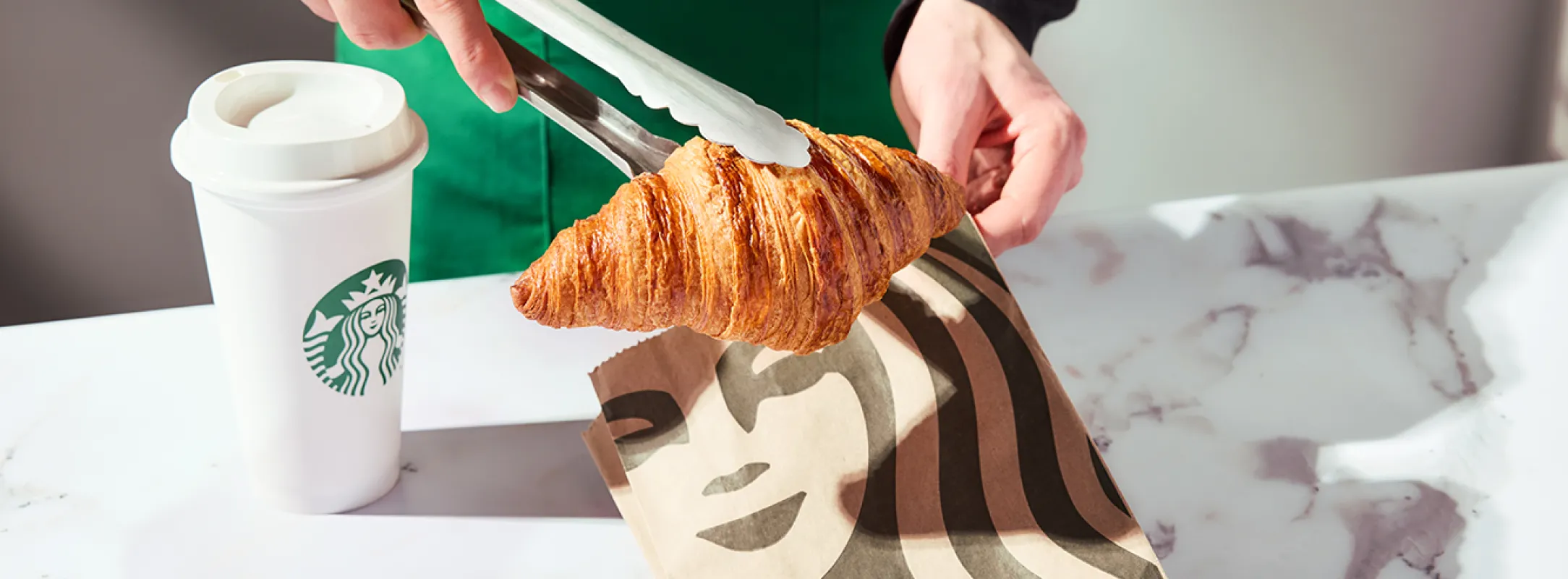 A delicious Starbucks® croissant being served alongside your favourite hot beverage