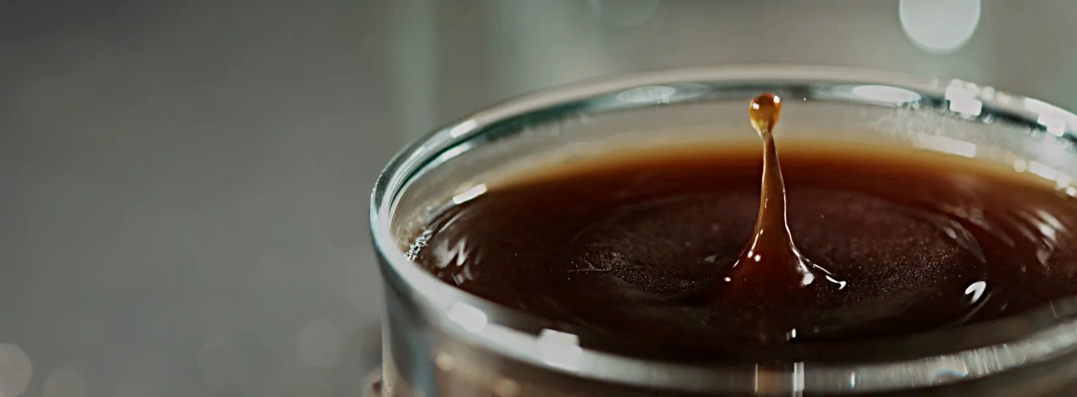 A close up photo of a coffee cup with the last drip splashing