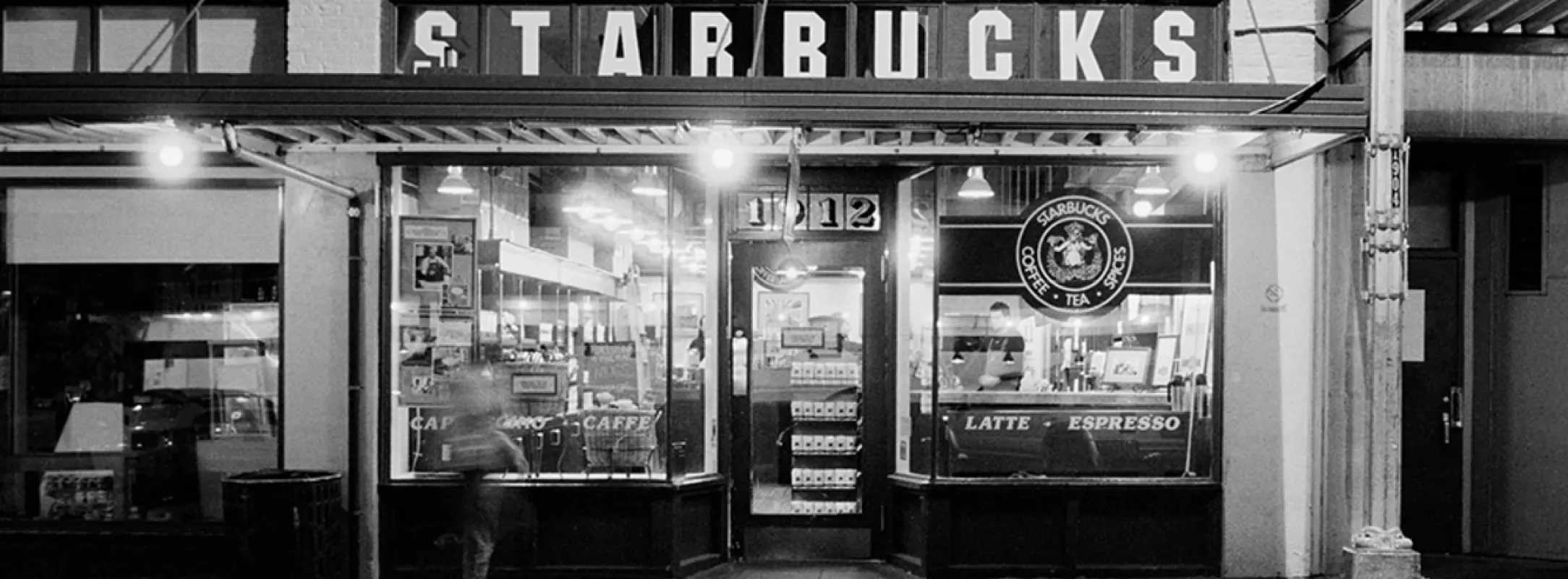 A black and white photo of the first Starbucks store in Seattle, WA