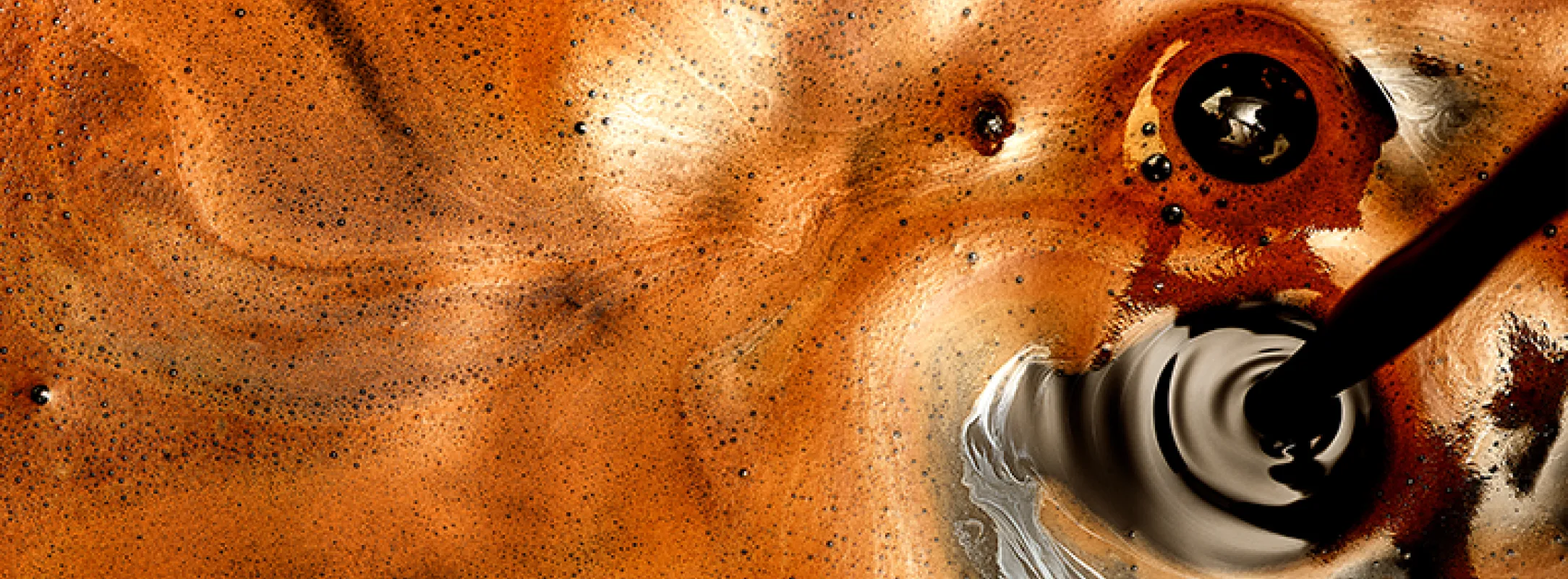 A close up image of a shot of espresso mid-pour