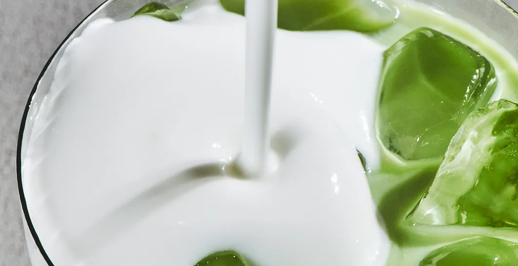 A close up of our new Iced Vanilla Protein Matcha Cold Foam being poured